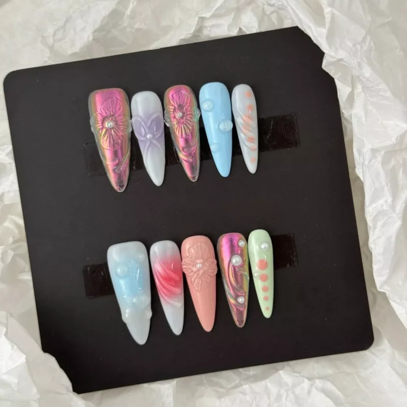 Styled layout of assorted pastel 3D nails with jelly bubbles, matte flowers, and pearlescent elements