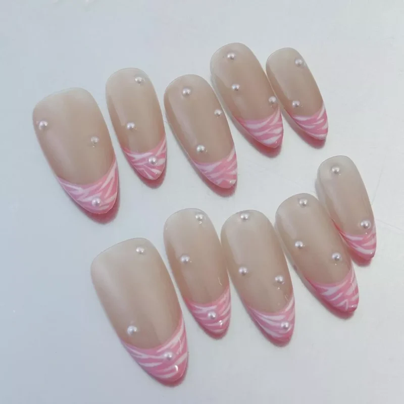Close-up of swirled French tip design on Pearl Pink Press-On Nails