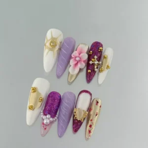 Close-up of long press-on nails with pink glitter and 3D butterfly charm