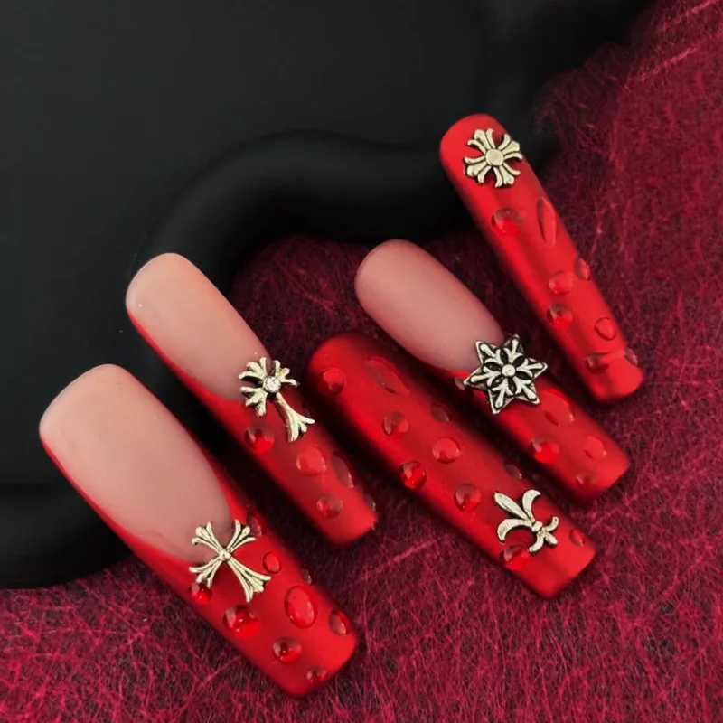 Gothic matte red press-on nails laid on crimson textured fabric