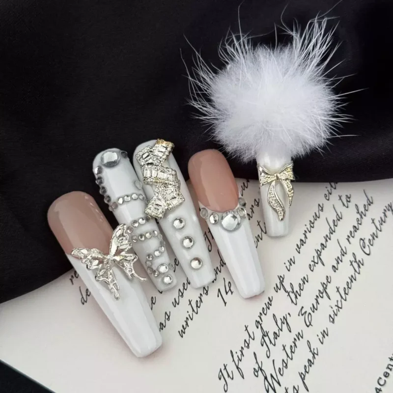 Long bridal press-on nails with nude base and luxury white accents, featuring soft pom detail