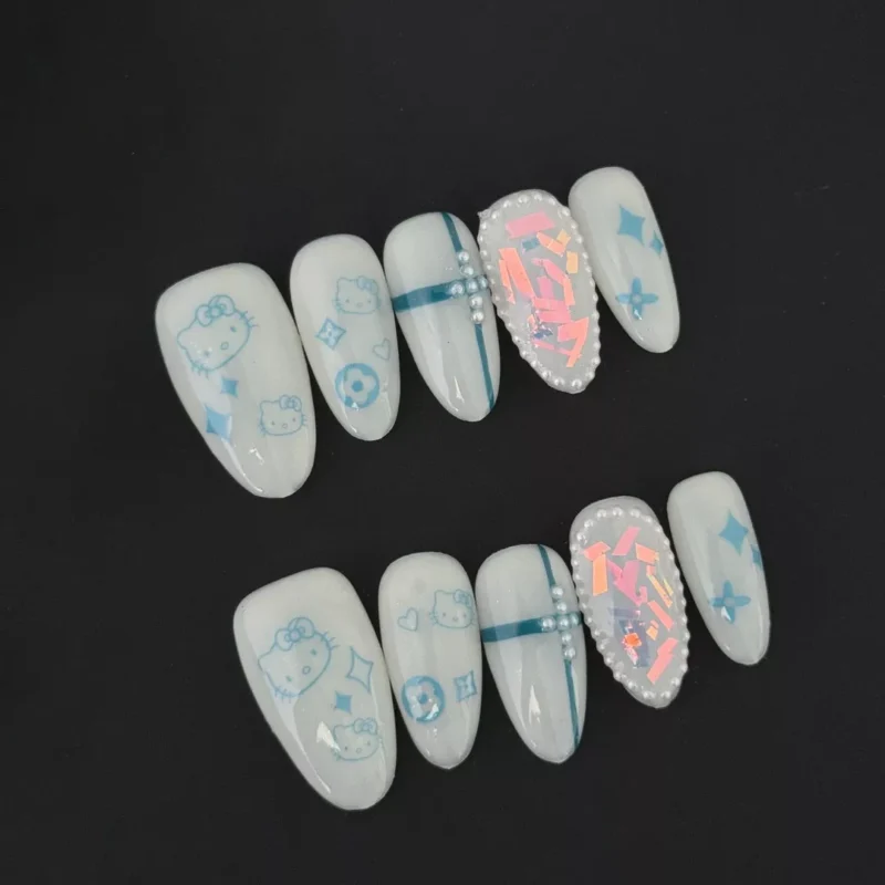 White cartoon press-on nails with blue kitty and pearl accents - full set view