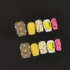 Yellow square press-on nails with rhinestone and sequin accents - full set display