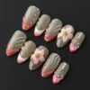 3D Sakura Press-On Nails with sheer nude base and sculpted pink tips, decorated with gold bead centers