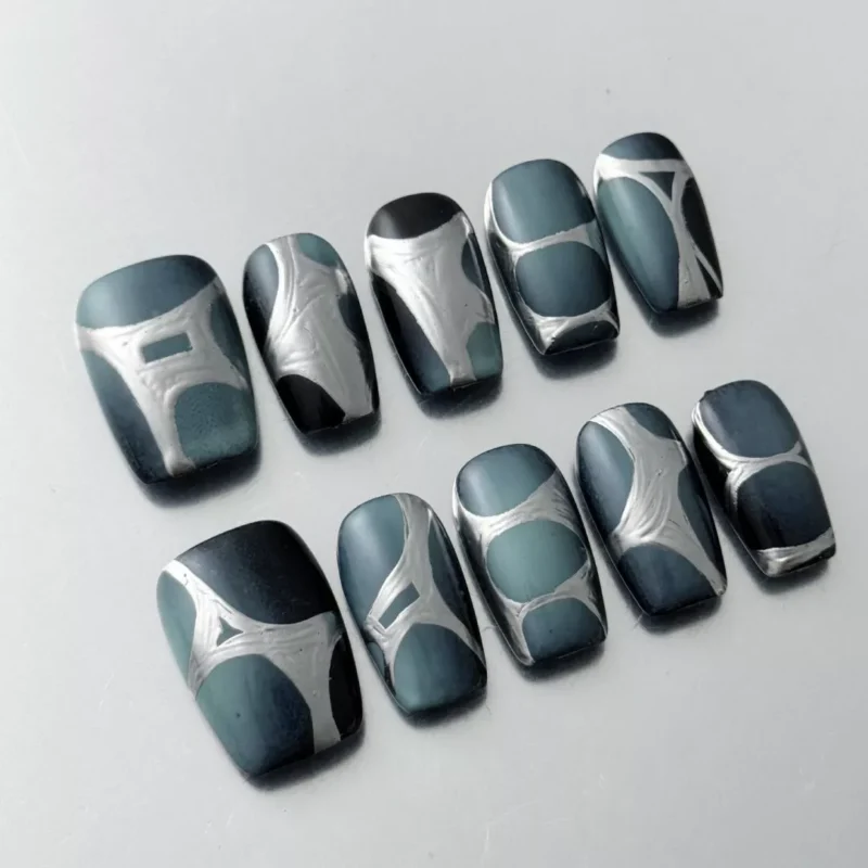 Close-up of abstract chrome press-on nails with glossy finish and geometric detail