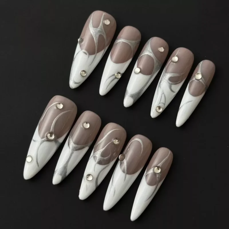Abstract silver line press-on nails with nude and white base, shown with rhinestone details in glossy finish – top view