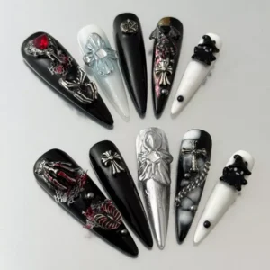 Long gothic press-on nails with 3D cross, skull, and gemstone decorations – top layout view