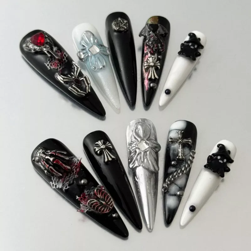 Long gothic press-on nails with 3D cross, skull, and gemstone decorations – top layout view