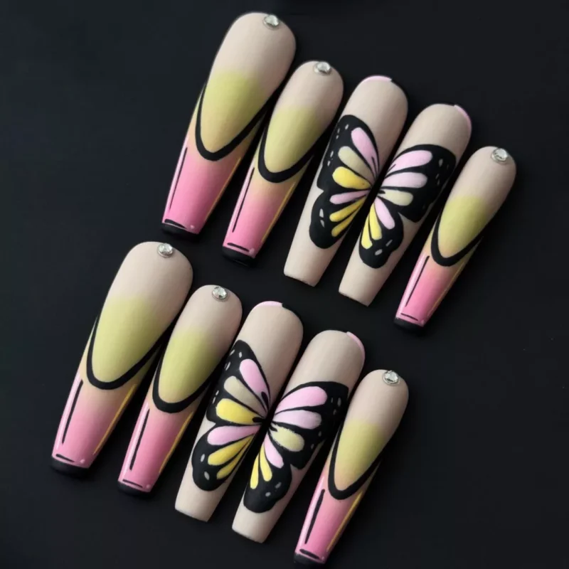 Butterfly Gradient Press-On Nails with soft pink and yellow ombre base and rhinestone butterfly accents – top angle
