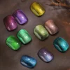 Iridescent gel nail swatches on dark background showcasing deep reflective finish.