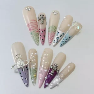 Close-up of coffin-shaped press-on nails featuring leopard accents and silver cross detail