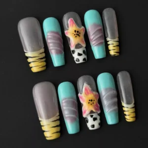 Close-up of cow print nail art on aqua and yellow base