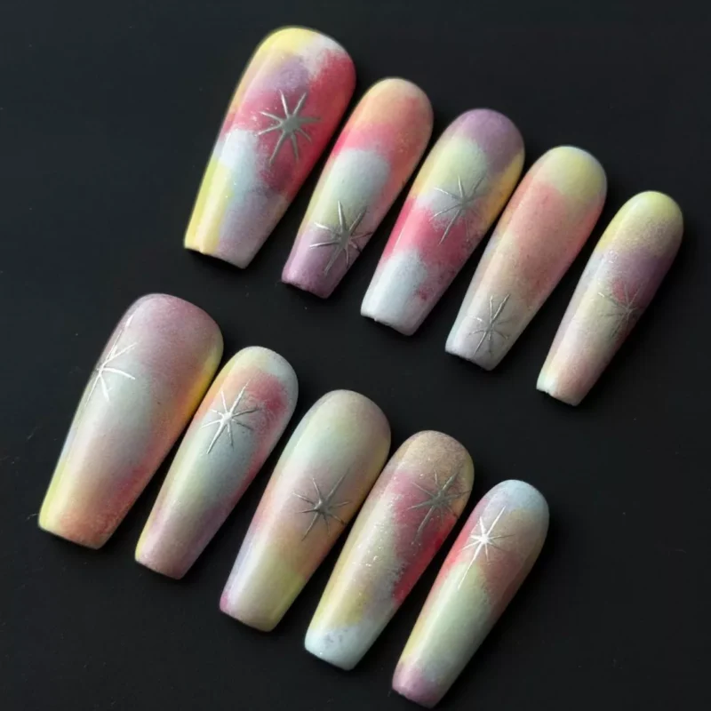Dreamy rainbow press-on nails with gradient glow and star pattern – front view display