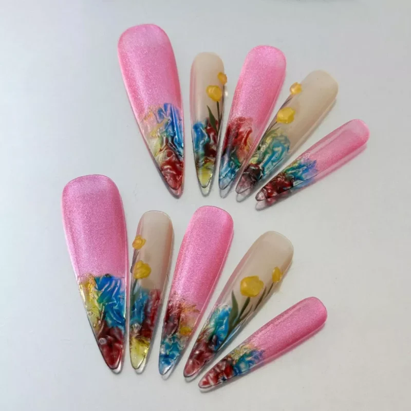 Side view of pink gradient fake nails with embedded flower nail art