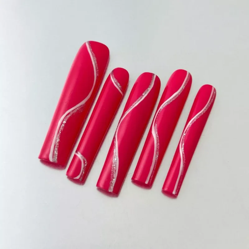 Glossy magenta coffin nails with silver line design on a nude hand – angled display