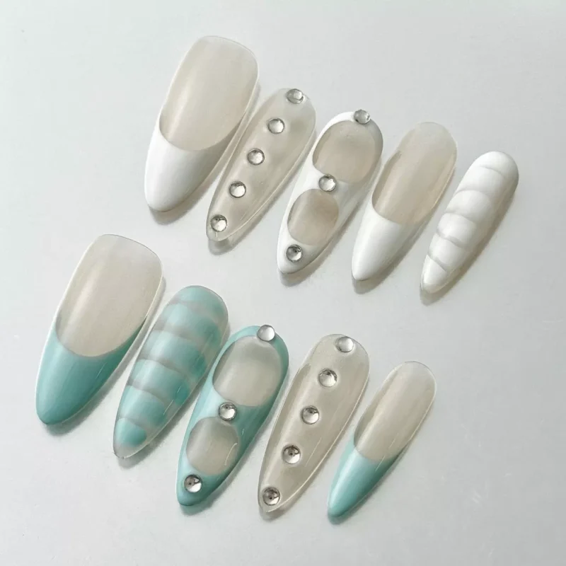 Side view of oval blue white marble nails featuring translucent white base and gemstone accents