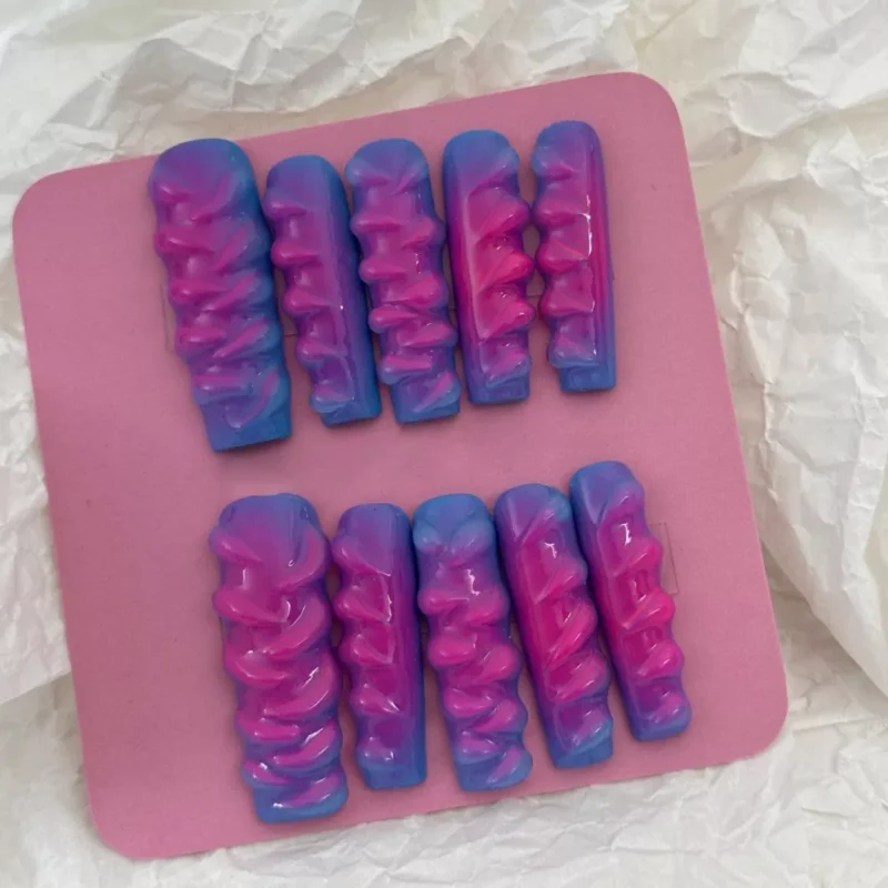 3D wave texture on pink and blue glossy press-on nails – overhead view