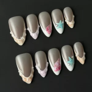 Medium-length almond nude press-on nails with 3D embellishments and glossy finish