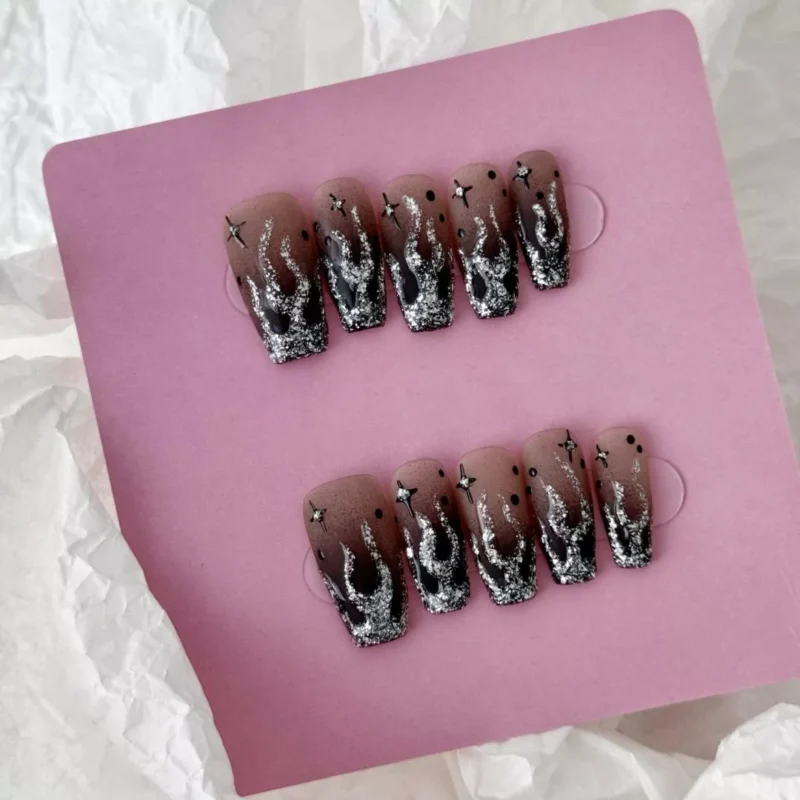 Medium-length square nails with black silver gradient, glitter flames, and rhinestones