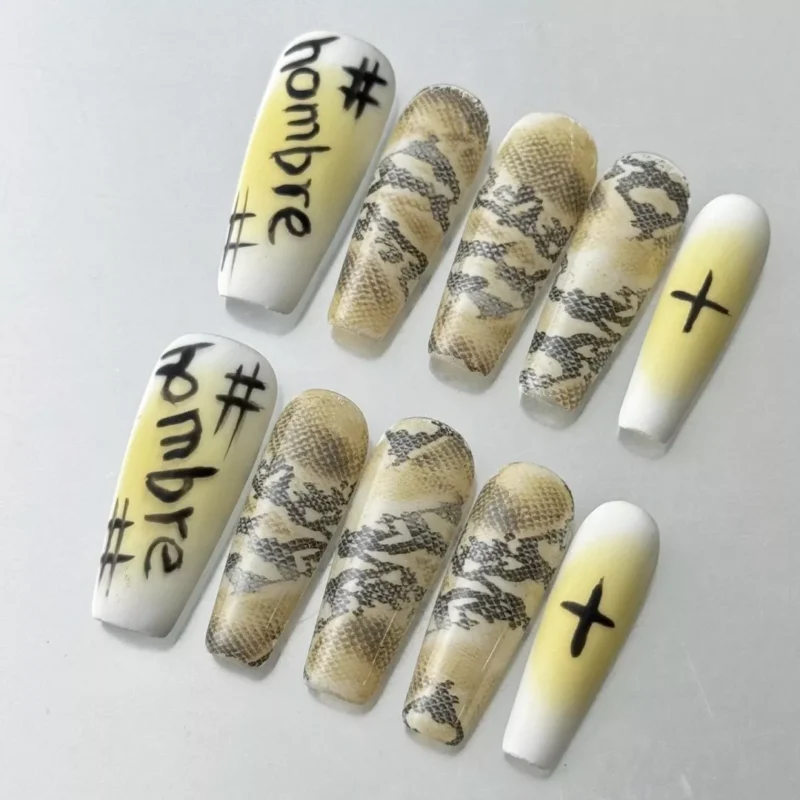 Close-up of yellow graffiti press-on nails with snake skin pattern and urban street motifs
