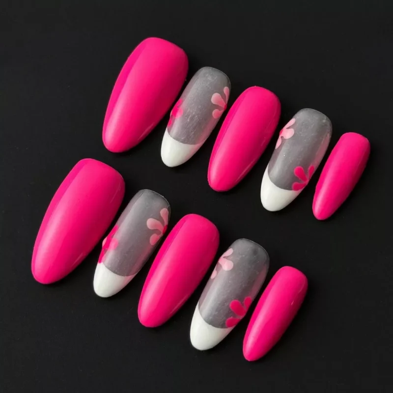 Mixed hot pink press-on nails with white V-tips and sheer base featuring floral silhouettes – front view