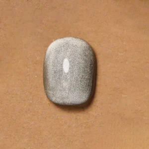 Macro shot of shimmering magnetic white cat eye gel on nude background