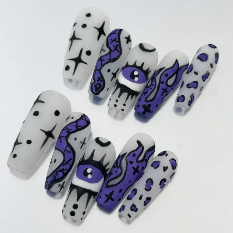 Close-up of matte white Gothic press-on nails with spooky snake and occult motifs