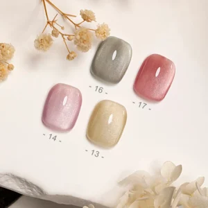 Focus on four pastel magnetic gel polish swatches laid with dried floral decor