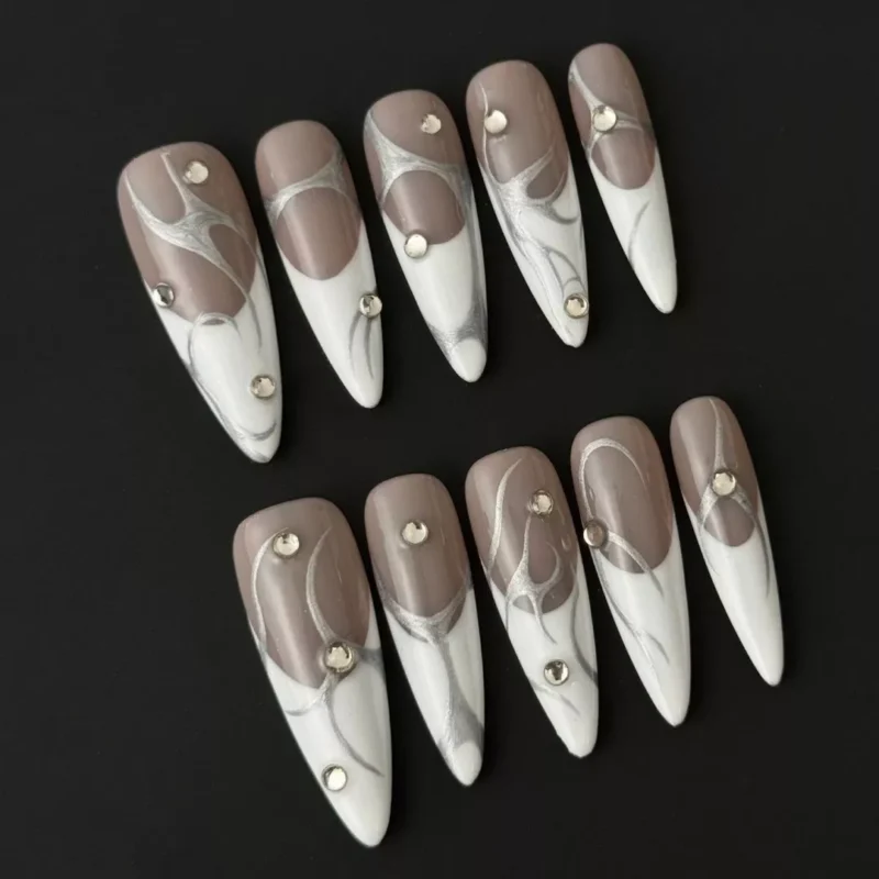 Side angle of modern minimalist nail art featuring glossy nude press-on nails with white tips and silver lines