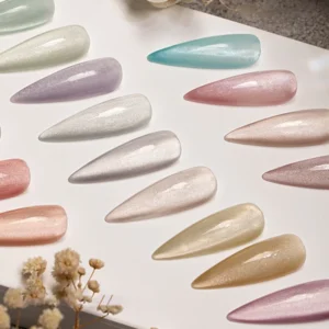 Close-up of magnetic pastel nail tips on glossy white background with floral accent