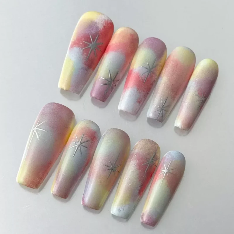 Close-up of pastel starlight gradient nails with matte rainbow finish and stars
