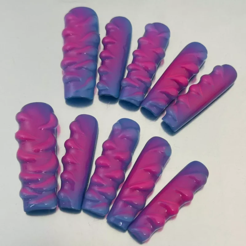 Vibrant pink and blue press-on nails with 3D sculpted wave detailing – angled layout