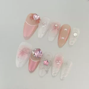 Almond-shaped iridescent press-on nails with pink pearl accents and sculpted bow charm