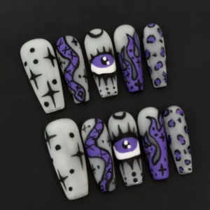 Purple Halloween nail design with coffin shape and spooky hand-drawn symbols