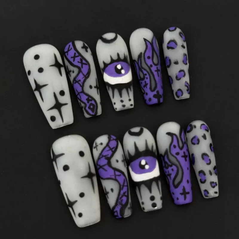 Purple Halloween nail design with coffin shape and spooky hand-drawn symbols