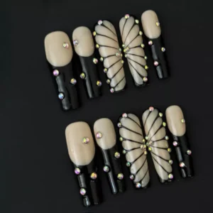 Detailed view of rhinestone butterfly accent nails on nude and black press-ons