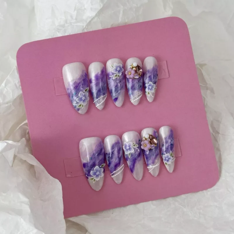 Romantic purple press-on nails with marble finish and floral gemstone designs