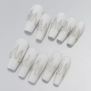 Close-up of silver flame accent nails on glossy white coffin-shaped tips