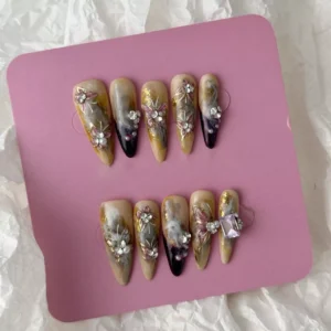 Set of smoky marble press-on nails in medium oval shape with sculpted florals and gem accents