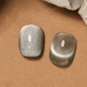 Close-up of two white cat eye gel nails showing shimmer and depth