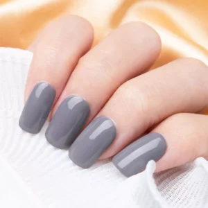 Hand with glossy gray gel nails under soft lighting