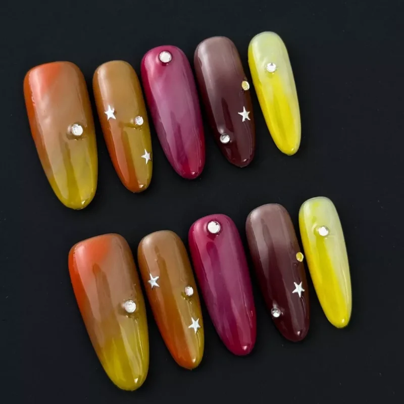 Long multicolor press-on nails with star and rhinestone accents – flat lay