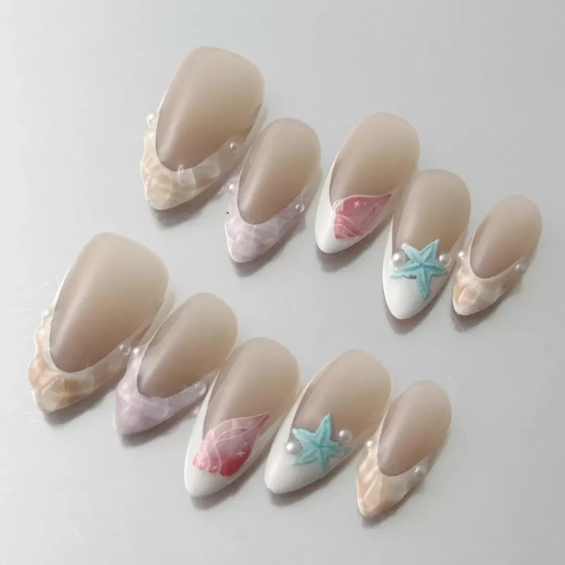 Close-up of starfish accent nail on nude press-on set with pearlescent details