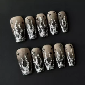Close-up on square nail tips featuring star charm ombre design in black and silver