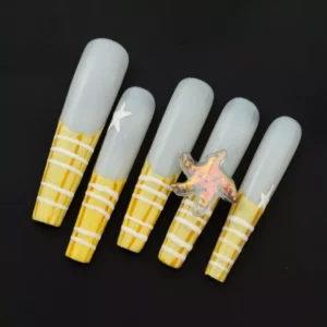 Striped yellow tip press-on nails with 3D starfish charm on sheer base – angled front view