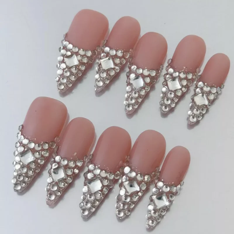 Rhinestone encrusted nude pink press-on nails with elegant French V-shape design