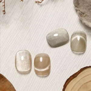Trio of white cat eye gel nails placed on textured white wood surface