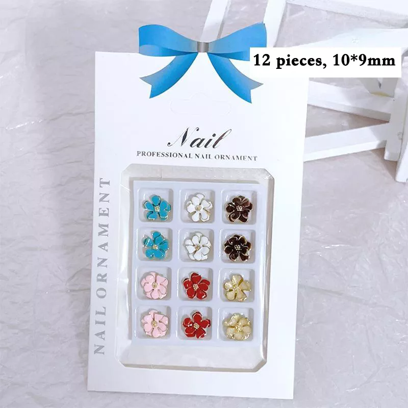 Twelve-piece boxed set of vintage metal flower nail charms in assorted colors