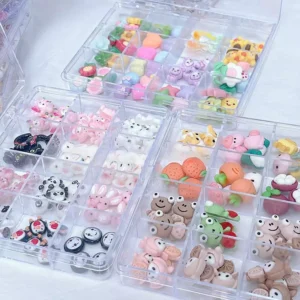 Close-up of mixed 3D animal and fruit-themed nail charms in transparent boxes