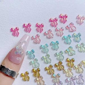 3D bow nail charms applied on long nude nail design